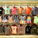 Children's clothing displayed on racks in a store.