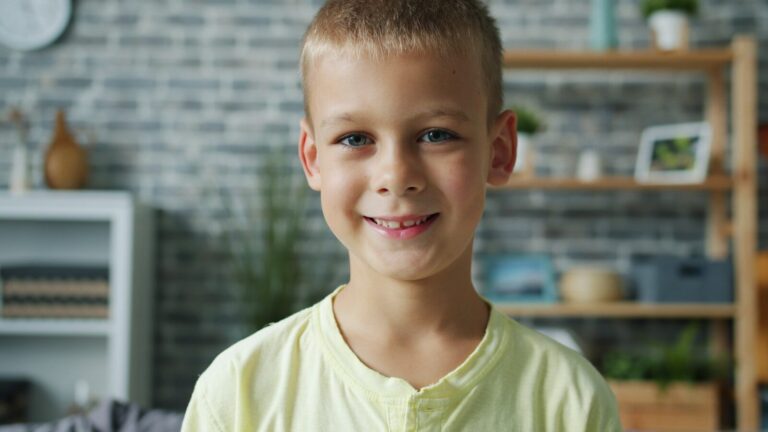 A young boy smiles at the camera.